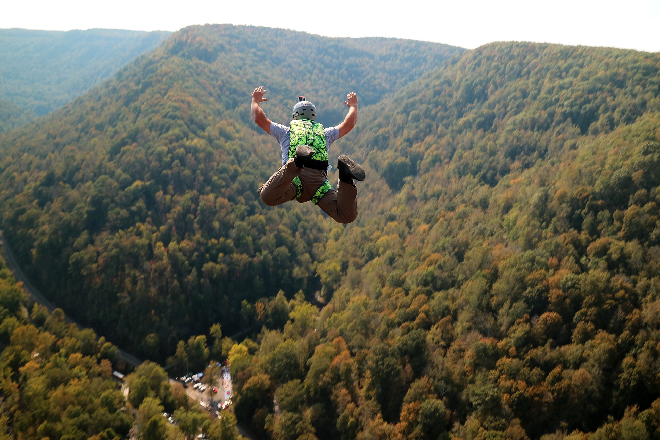 un homme qui saute d'une falaise dans le vide avec un parachute